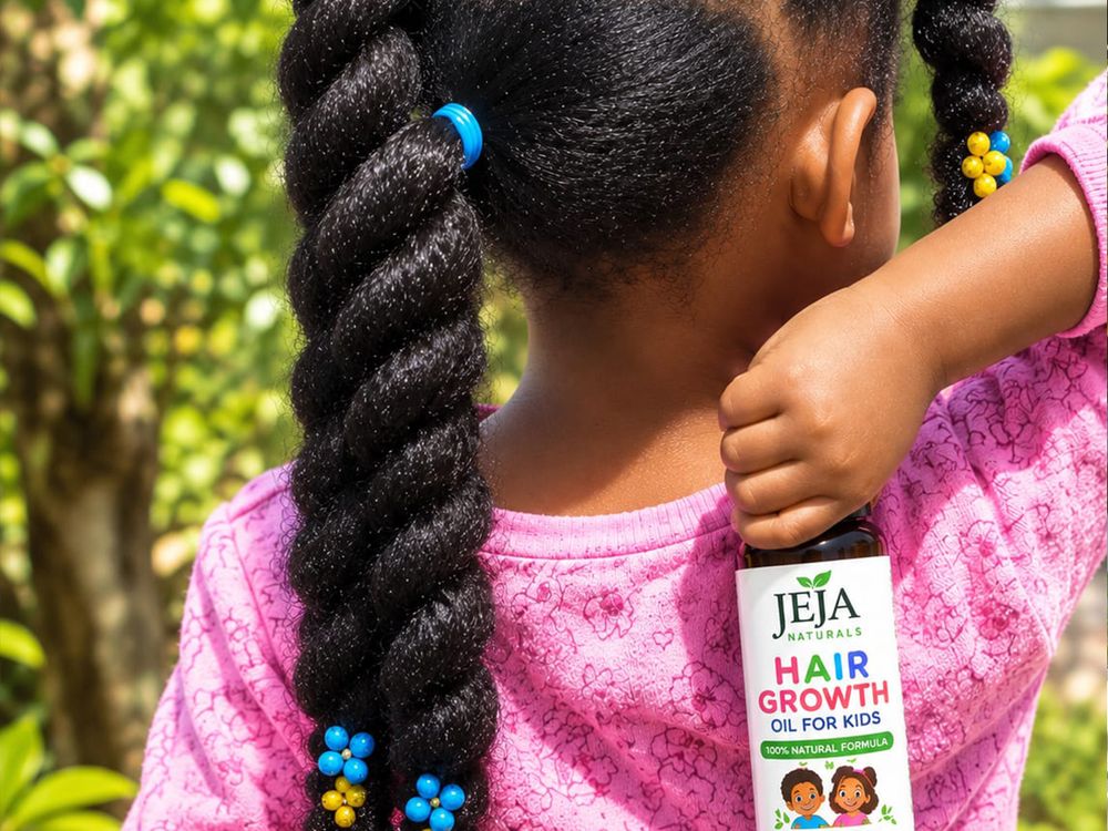 Girl in a pink top with a long braided plait holding a bottle of JEJA Naturals Hair Growth Oil for Kids in a garden